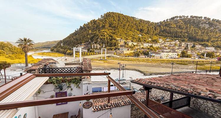 Vista desde una terraza sobre un río y casas en la ladera.