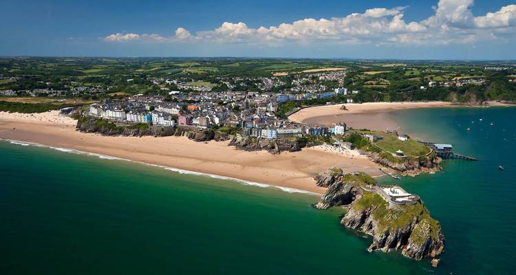 Vue aérienne d'une ville côtière avec plages et falaises.
