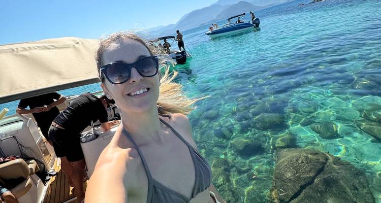 Personne prenant un selfie sur un bateau dans une eau claire.