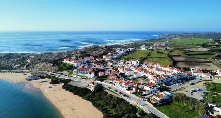 Vue aérienne d'un village côtier avec de vastes plages.