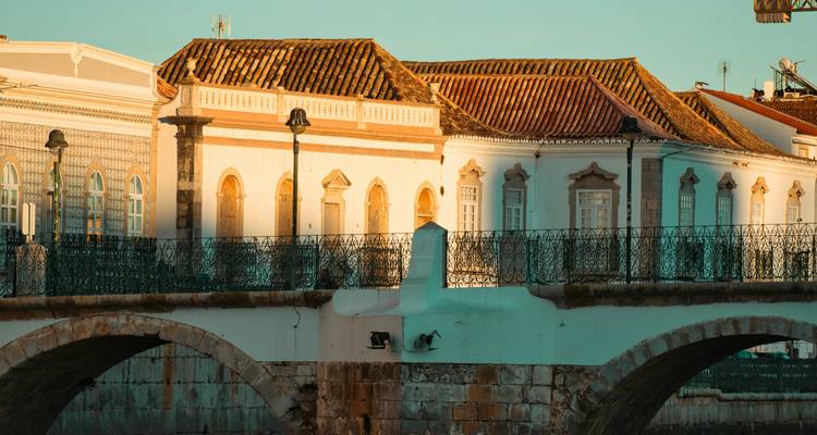 Pont historique et bâtiments aux couleurs pastel au coucher du soleil.