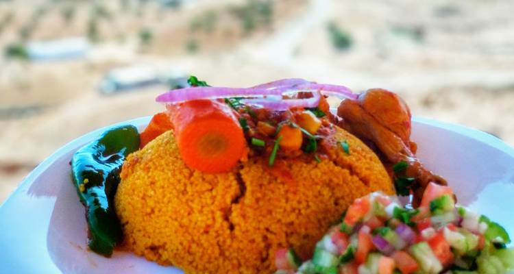 A plate of couscous with vegetables and meat.