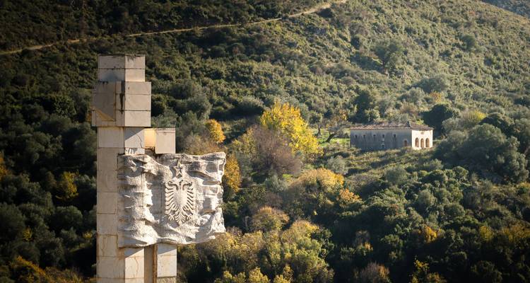 Monument avec un blason ancien sur une montagne.