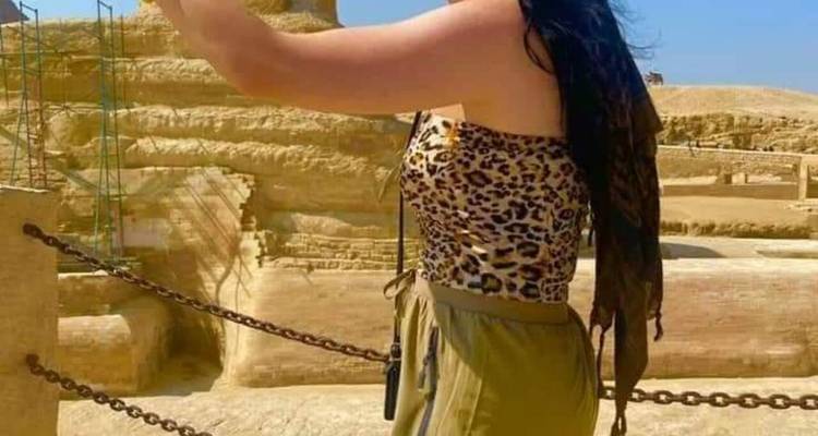 Personne posant devant une structure ancienne.