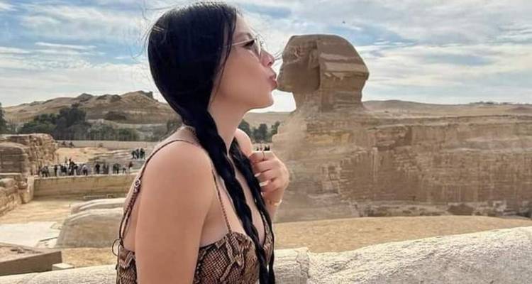 Touriste posant de manière ludique avec le Sphinx.