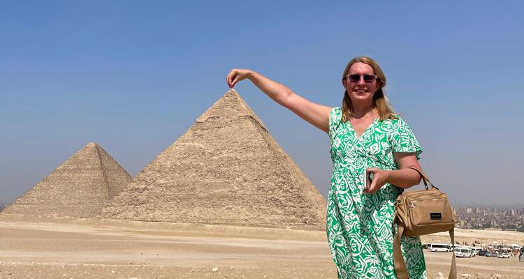 Personne posant devant les pyramides, imitant le fait de toucher le sommet.