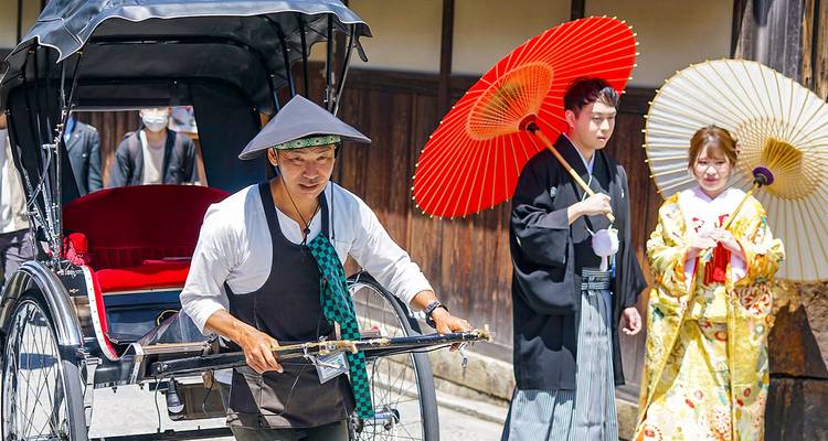 Rickshaw driver and people with traditional umbrellas.