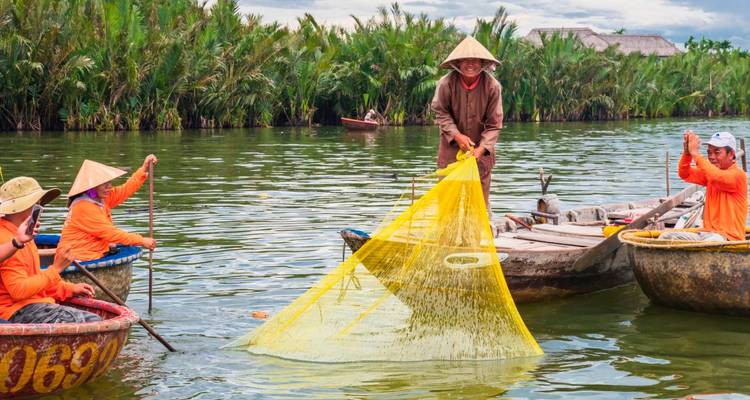 Des pêcheurs avec des filets sur des bateaux ronds traditionnels sur une rivière.