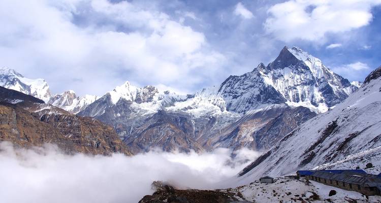 Majestueuse chaîne de montagnes aux sommets enneigés au-dessus des nuages.