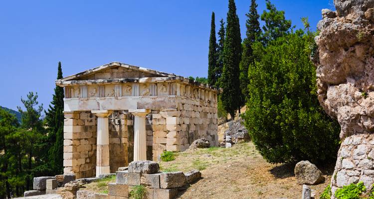 Ruines d'un temple antique entourées de verdure.