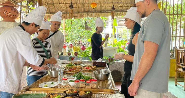 Cours de cuisine avec des participants observant une démonstration.