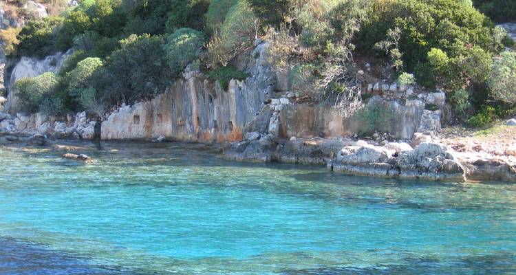 Paysage côtier rocheux avec une eau bleue claire.