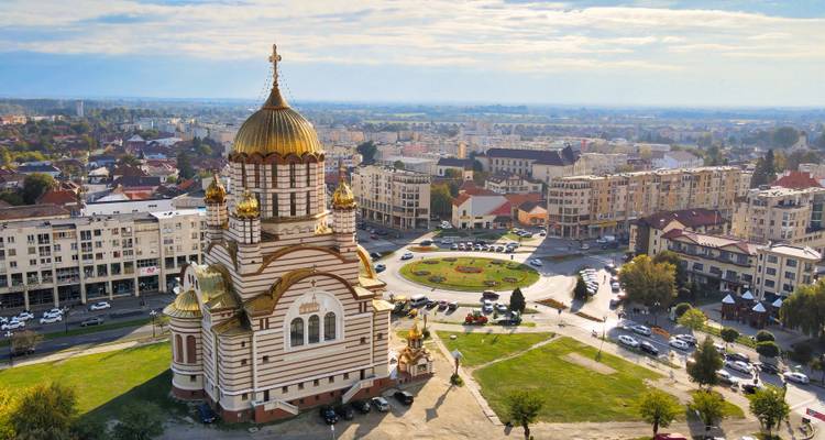 Vue aérienne d'une église avec un dôme doré au milieu d'un paysage urbain.