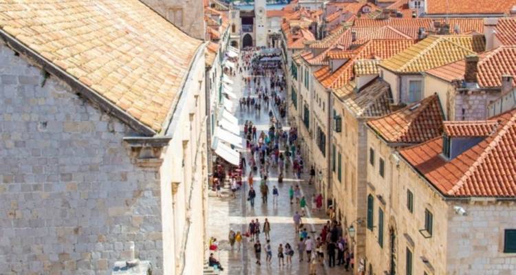 Mensen die langs een historische straat in Dubrovnik wandelen.