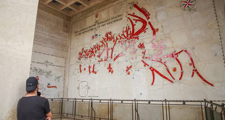Visitor observing a large wall map of historical significance.