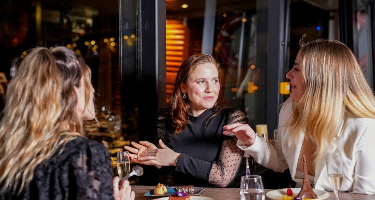Drie mensen die dineren en een gesprek voeren.