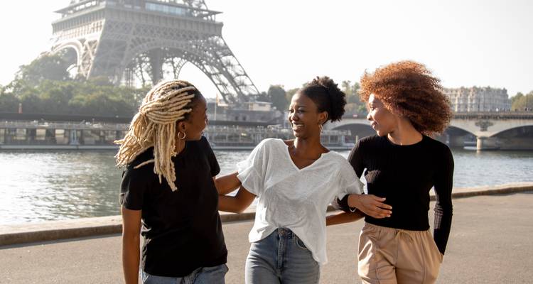 Tres amigos caminando con la Torre Eiffel de fondo.