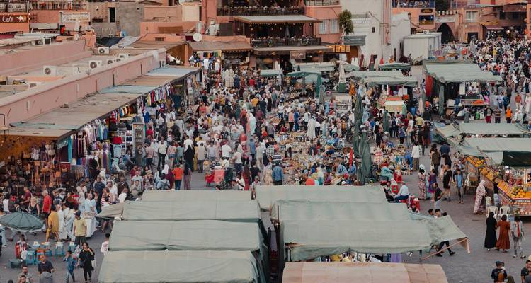 Plaza de mercado bulliciosa llena de gente y puestos.