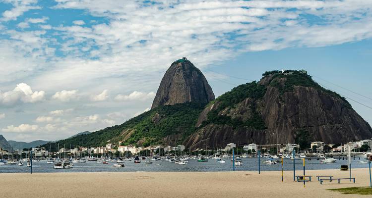 View of Sugarloaf Mountain in Rio de Janeiro with sailboats in the foreground.