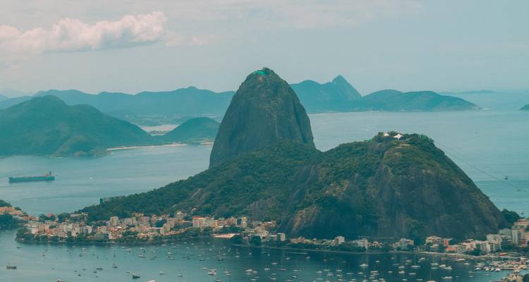 Aerial view of Sugarloaf Mountain surrounded by the sea and cityscape.