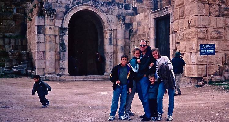 Eine Gruppe von Menschen, die vor antiken Steingebäuden posiert.