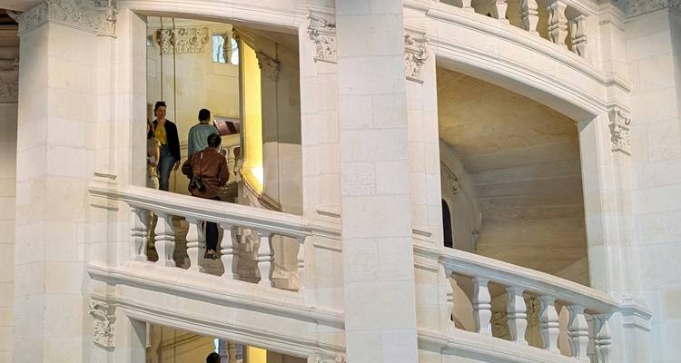 Deux femmes prenant un selfie à l'entrée d'une plage avec des plaques commémoratives.