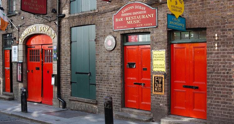 Bar avec des portes rouge vif et une façade en brique