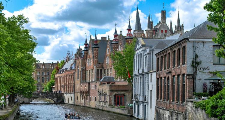Charmante scène de canal avec des bâtiments médiévaux et une excursion en bateau à Bruges.