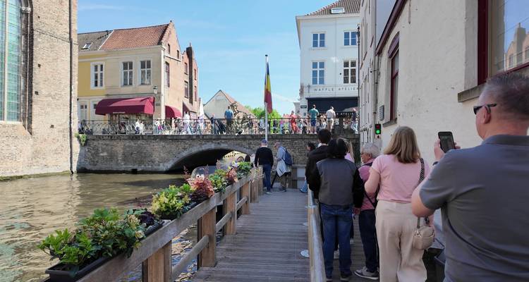 Des personnes marchant le long d'un canal avec un pont à Bruges.