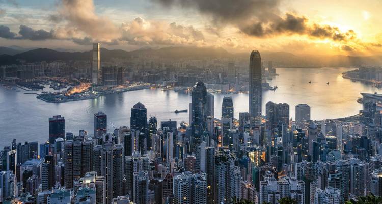 Hong Kong stadsgezicht met havenzicht bij zonsondergang.