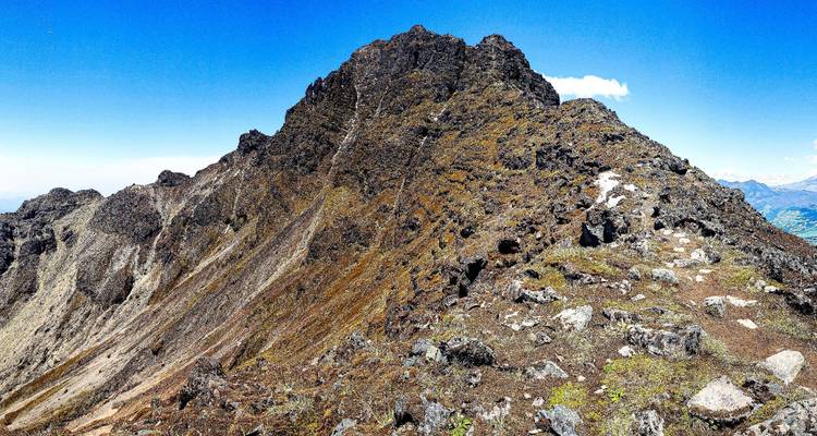 Sommet de montagne avec un terrain rocheux et un ciel dégagé.