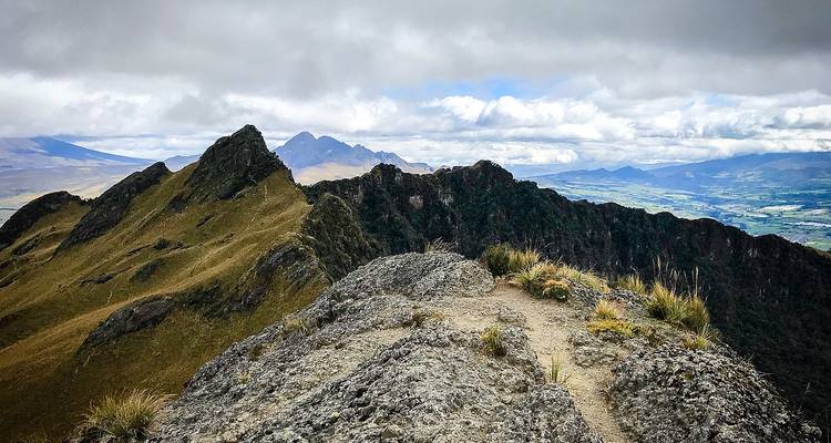 Crête de montagne avec ciel nuageux et vues lointaines.