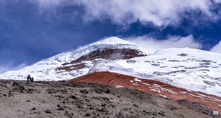 Paisaje montañoso con picos cubiertos de hielo y una figura solitaria.
