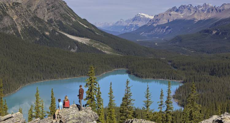 Familie geniet van het uitzicht op een prachtig meer en bergen.