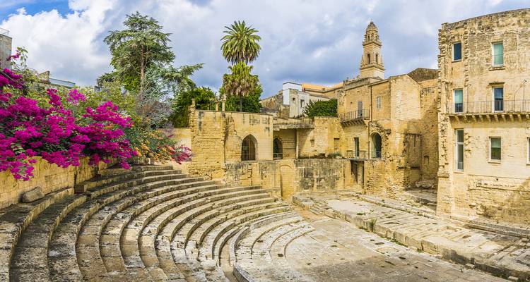 Ruinen eines antiken römischen Amphitheaters, geschmückt mit blühender Bougainvillea im historischen Zentrum von Lecce.
