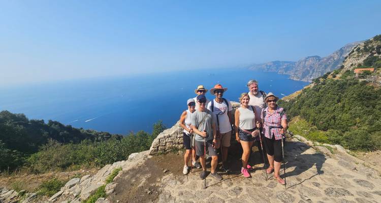 Groupe de touristes posant devant une vue panoramique de la côte.