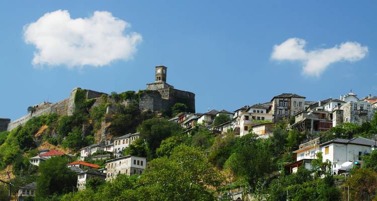 Vista panorámica de una ciudad en la ladera de una colina con un fuerte en la cima.