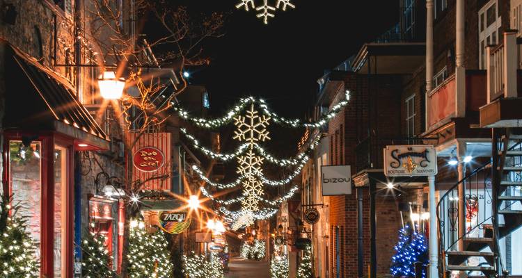 Rue festive décorée avec des lumières et des décorations de fête la nuit.