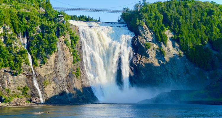 Grande cascade avec verdure environnante et ciel bleu.