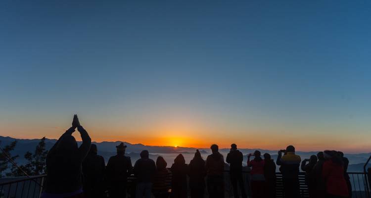 Des gens se sont rassemblés pour voir le lever du soleil sur une terrasse.
