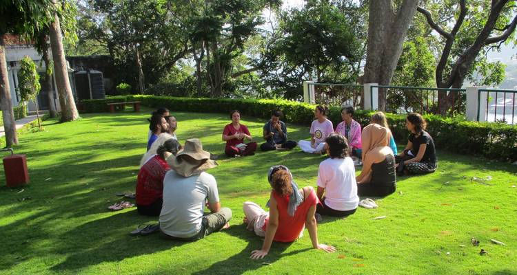 Groupe assis en cercle sur une pelouse.