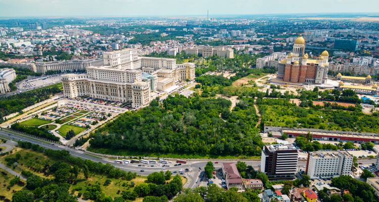Grande ville avec un grand palais proéminent et un vaste espace vert.