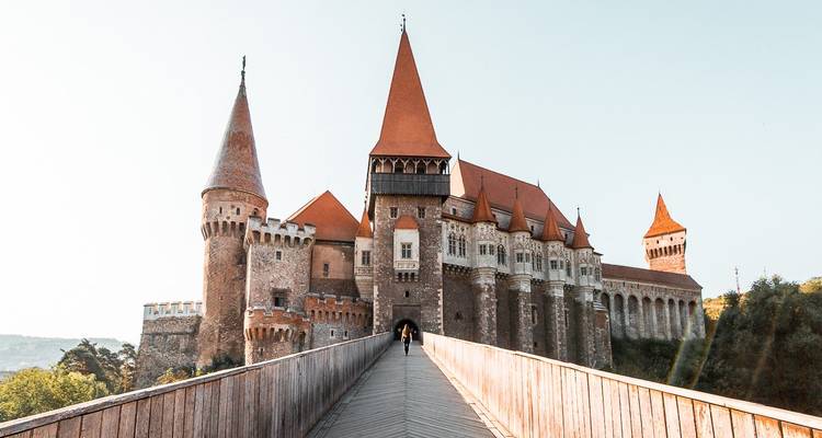 Château médiéval avec des toits de tuiles rouges par une journée ensoleillée.