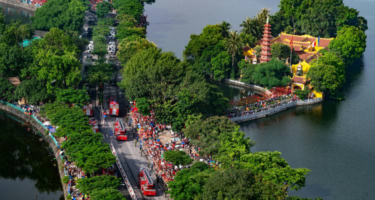 Vista aérea de la península de la Pagoda Tran Quoc entre exuberante vegetación y calles concurridas.