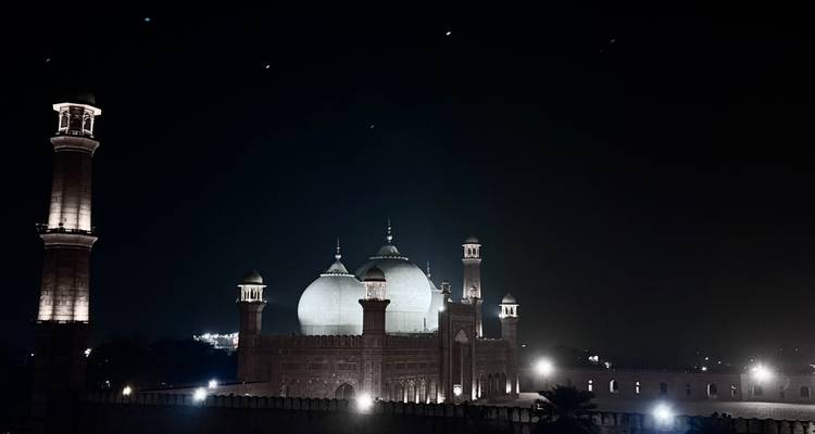 Vue nocturne des dômes illuminés et des minarets de la Mosquée Badshahi