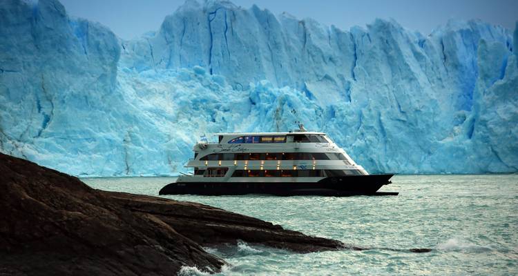 Navire de croisière naviguant près d'un glacier massif.