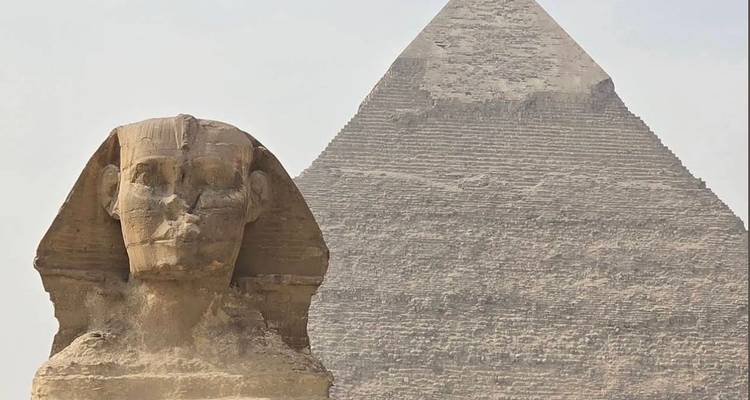 Le Sphinx avec la Grande Pyramide de Gizeh en arrière-plan sous un ciel dégagé.