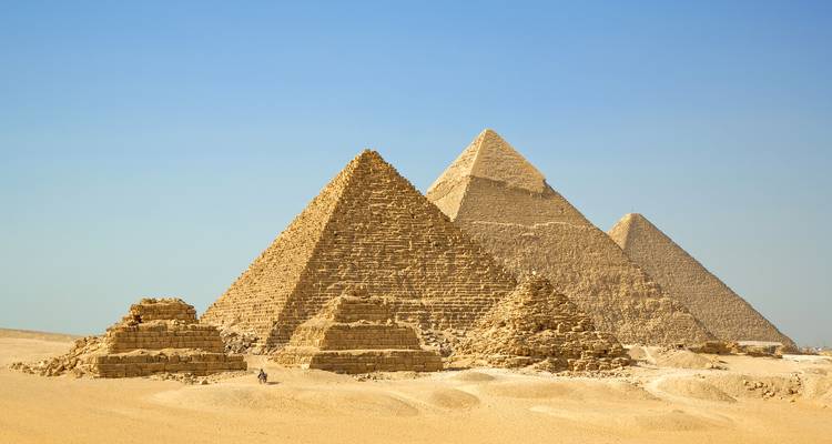 Zicht op de piramides van Gizeh onder een heldere blauwe hemel.