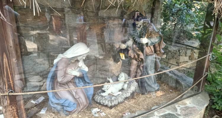 Vitrine en verre avec des statues religieuses dans un cadre extérieur.