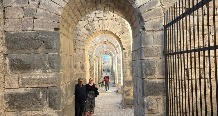 Arches en pierre avec des personnes dans un site archéologique.